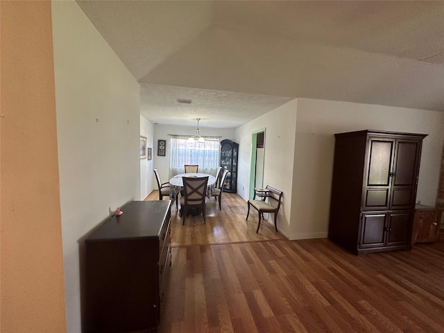 hall with dark wood-style floors, a textured ceiling, visible vents, and baseboards