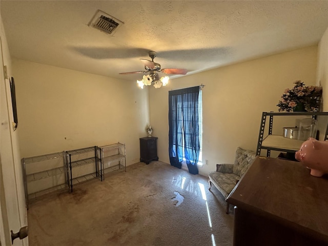 interior space with a ceiling fan, carpet, visible vents, and a textured ceiling