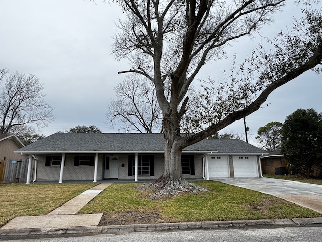 ranch-style home featuring an attached garage, concrete driveway, brick siding, and a front yard