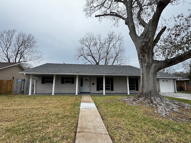 view of front of property featuring a garage, driveway, roof with shingles, a front lawn, and brick siding