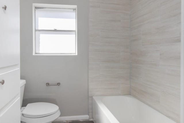 full bathroom featuring toilet and baseboards