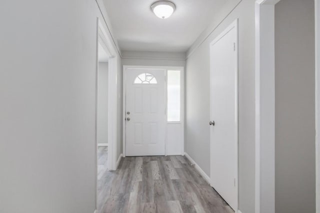 doorway with baseboards and wood finished floors