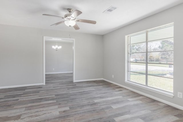 unfurnished room with a wealth of natural light, baseboards, and wood finished floors