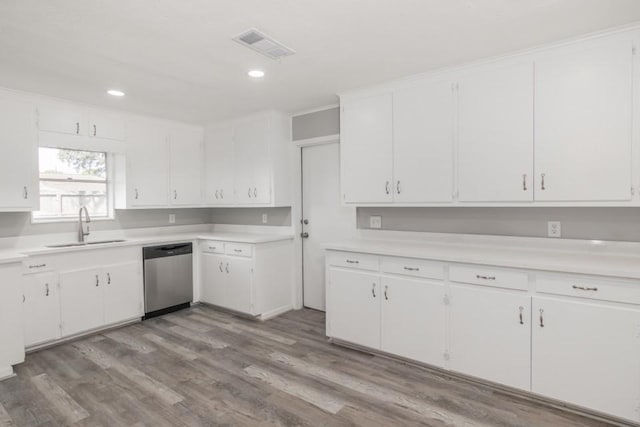 kitchen with visible vents, dishwasher, light countertops, white cabinets, and a sink