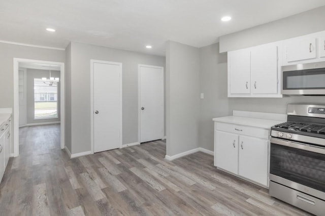 kitchen with light wood-style flooring, appliances with stainless steel finishes, white cabinetry, and light countertops
