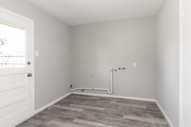 laundry room with hookup for a washing machine, baseboards, wood finished floors, and laundry area