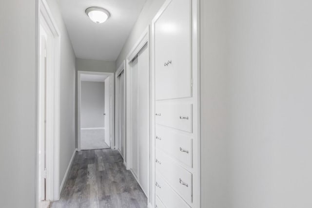 corridor with baseboards and light wood-type flooring