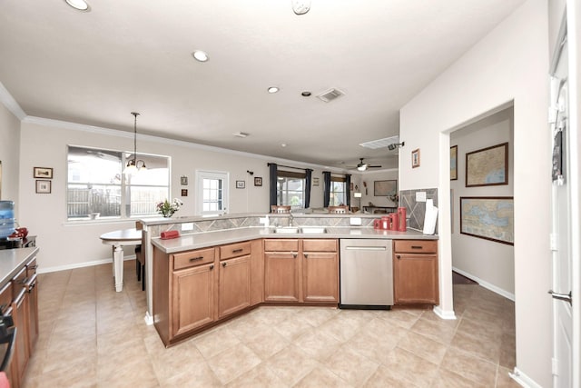 kitchen featuring brown cabinets, light countertops, visible vents, stainless steel dishwasher, and a sink