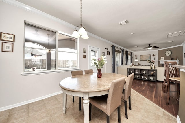 dining space featuring light tile patterned floors, baseboards, visible vents, and crown molding