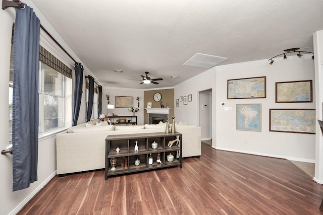 living area with a fireplace, a ceiling fan, baseboards, ornamental molding, and dark wood finished floors