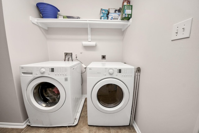 washroom featuring laundry area, baseboards, and separate washer and dryer