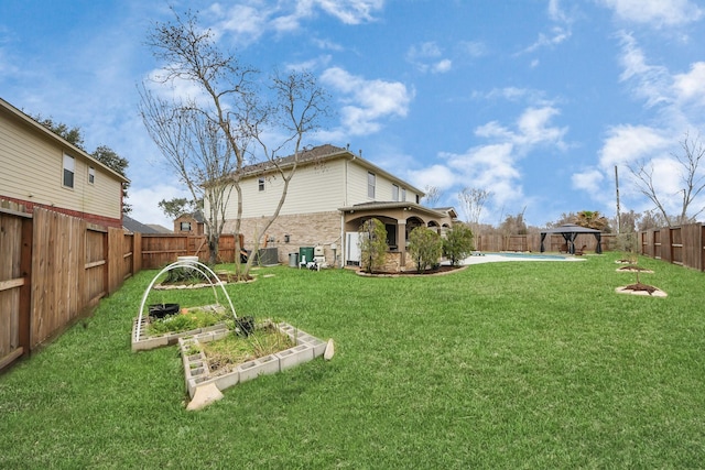 view of yard featuring a fenced backyard, a vegetable garden, and a gazebo