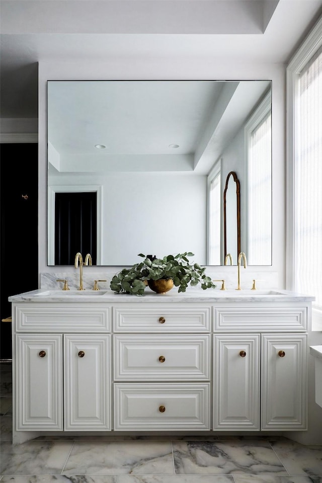 bathroom featuring a wealth of natural light, marble finish floor, and a sink