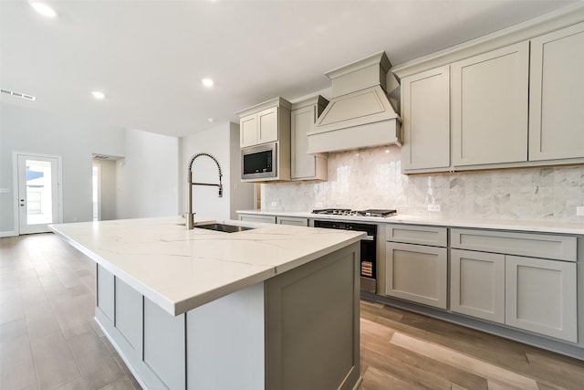 16319 Placid Stream St, Conroe, TX 77302 - kitchen with a sink, gray cabinets, custom range hood, appliances with stainless steel finishes, and backsplash