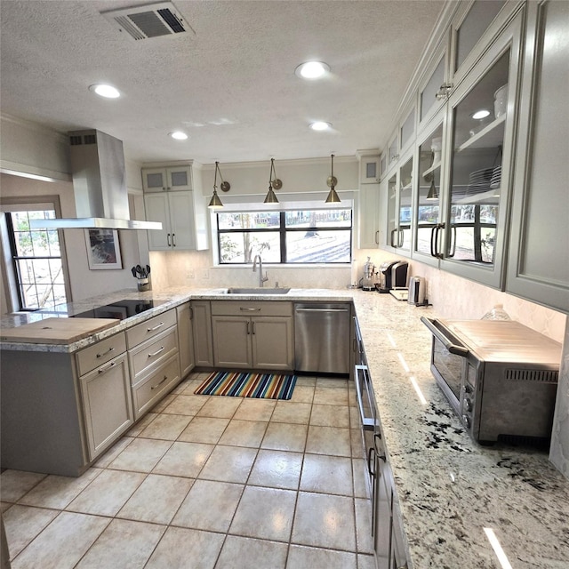 kitchen with a sink, dishwasher, island exhaust hood, backsplash, and visible vents