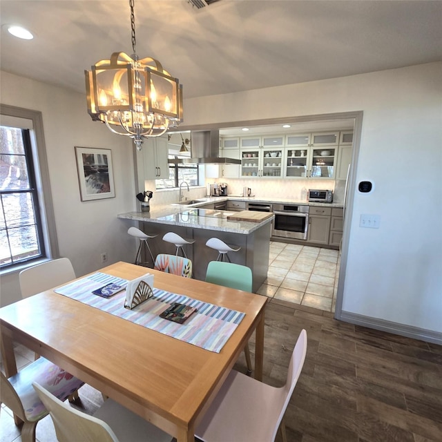 dining area featuring recessed lighting, a notable chandelier, light wood finished floors, and a toaster