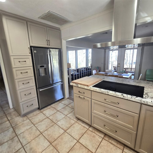 kitchen featuring stainless steel refrigerator with ice dispenser, island exhaust hood, visible vents, light tile patterned floors, and black electric stovetop