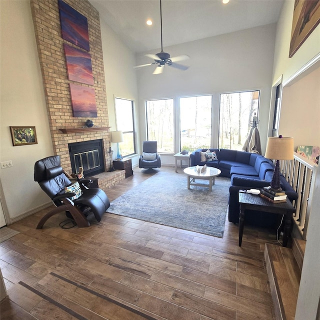 living room featuring a ceiling fan, a brick fireplace, high vaulted ceiling, wood-type flooring, and recessed lighting