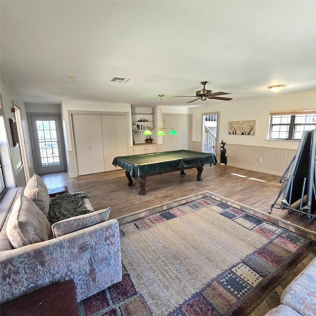 playroom with visible vents, wood finished floors, a wainscoted wall, pool table, and a ceiling fan