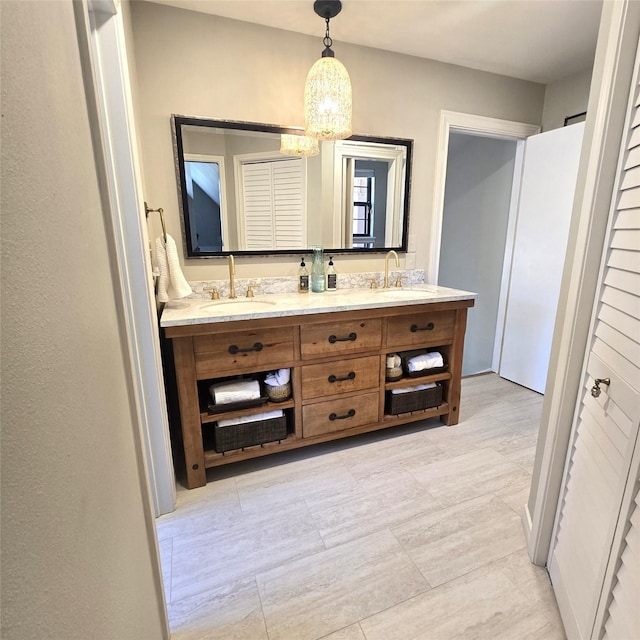 bathroom with double vanity, a sink, and a notable chandelier