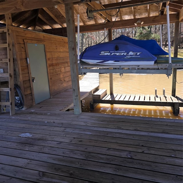 wooden terrace with a boat dock and boat lift