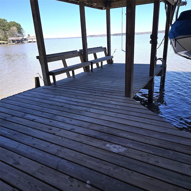 dock area with a water view and boat lift