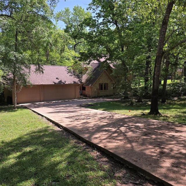 view of front of home with a garage, concrete driveway, and a front yard