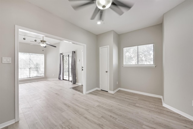 empty room featuring a ceiling fan, light wood-style flooring, and baseboards