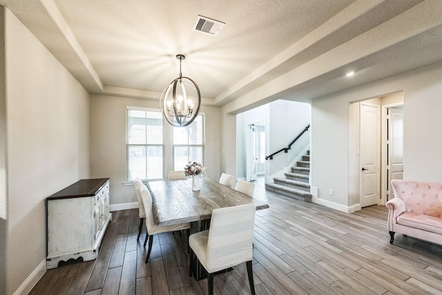 dining space with visible vents, stairway, a raised ceiling, and dark wood finished floors