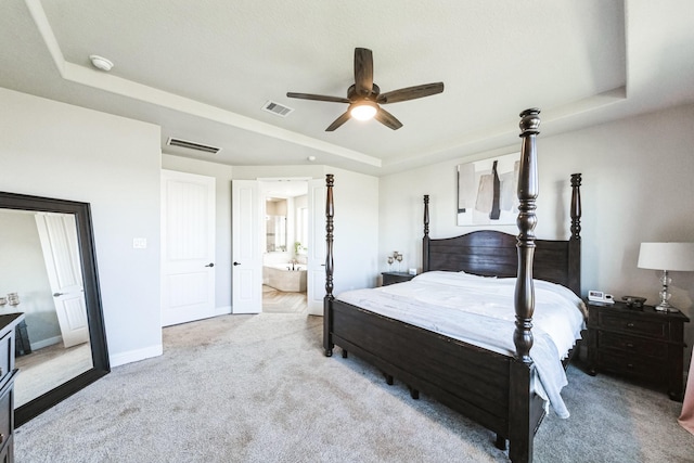 bedroom with a tray ceiling, baseboards, visible vents, and carpet flooring