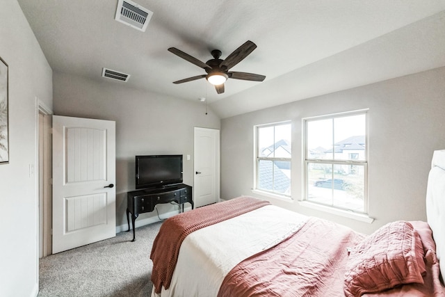 carpeted bedroom featuring lofted ceiling, visible vents, and ceiling fan