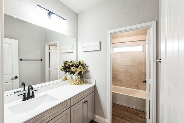 bathroom with bathing tub / shower combination, wood finished floors, and vanity