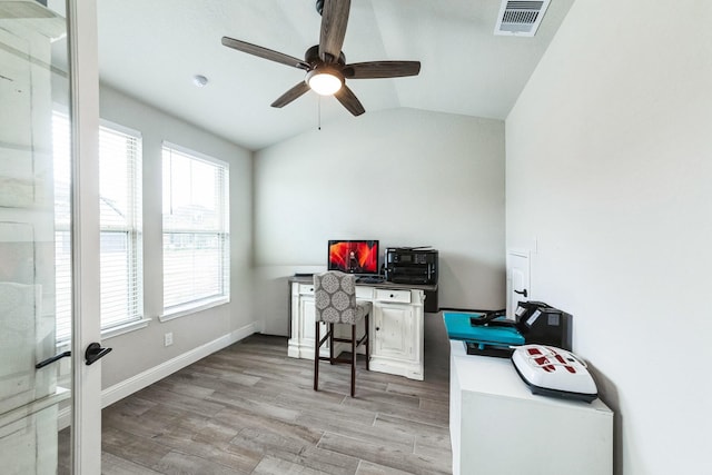 home office featuring visible vents, baseboards, vaulted ceiling, a ceiling fan, and light wood-type flooring