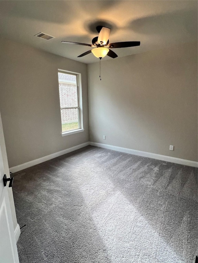 carpeted spare room with a ceiling fan, visible vents, and baseboards