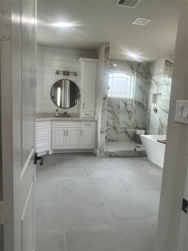 bathroom featuring visible vents, a freestanding bath, vanity, and a marble finish shower