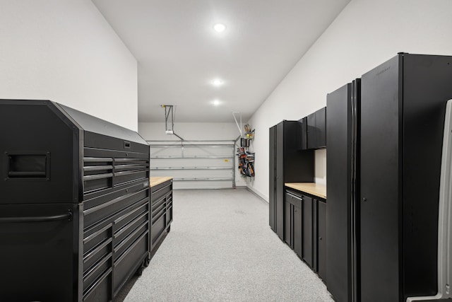 garage with freestanding refrigerator and recessed lighting