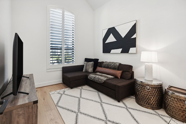 living area with baseboards and wood finished floors