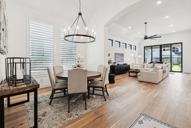 dining area featuring arched walkways, ceiling fan with notable chandelier, recessed lighting, and light wood-style floors