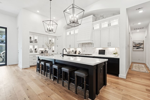 kitchen featuring white cabinets, glass insert cabinets, and light countertops