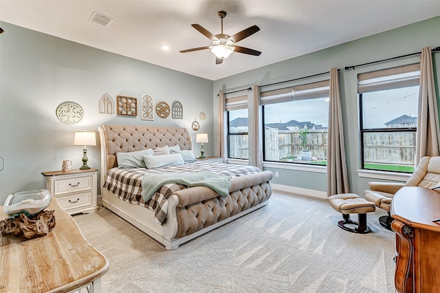 bedroom featuring baseboards, ceiling fan, visible vents, and light colored carpet