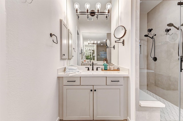 bathroom with tiled shower and vanity