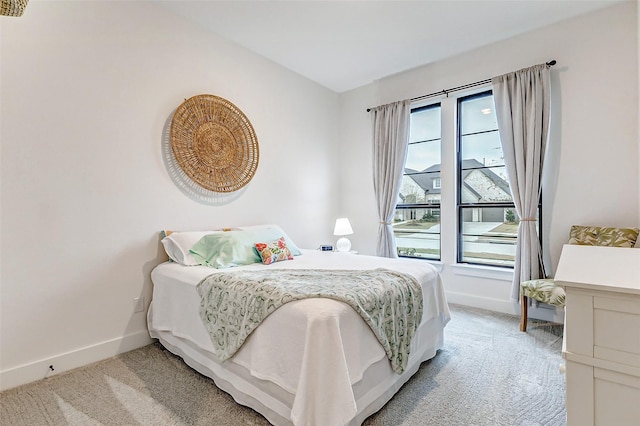 bedroom featuring light carpet and baseboards