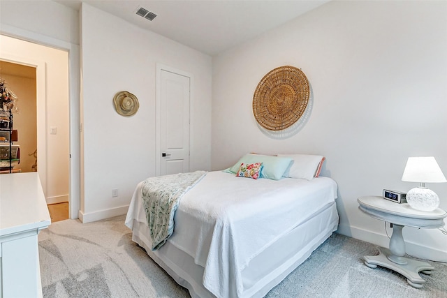 bedroom featuring baseboards, visible vents, and light colored carpet