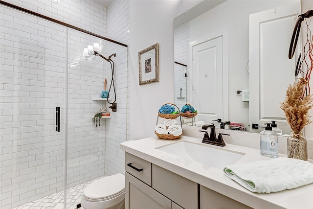 bathroom featuring toilet, a stall shower, and vanity