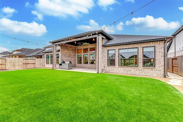 back of property with a patio area, a fenced backyard, a lawn, and brick siding