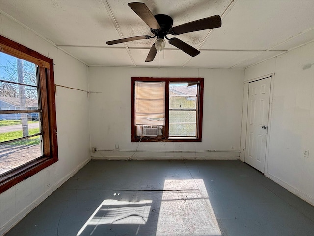 unfurnished room featuring baseboards, concrete floors, cooling unit, and a healthy amount of sunlight