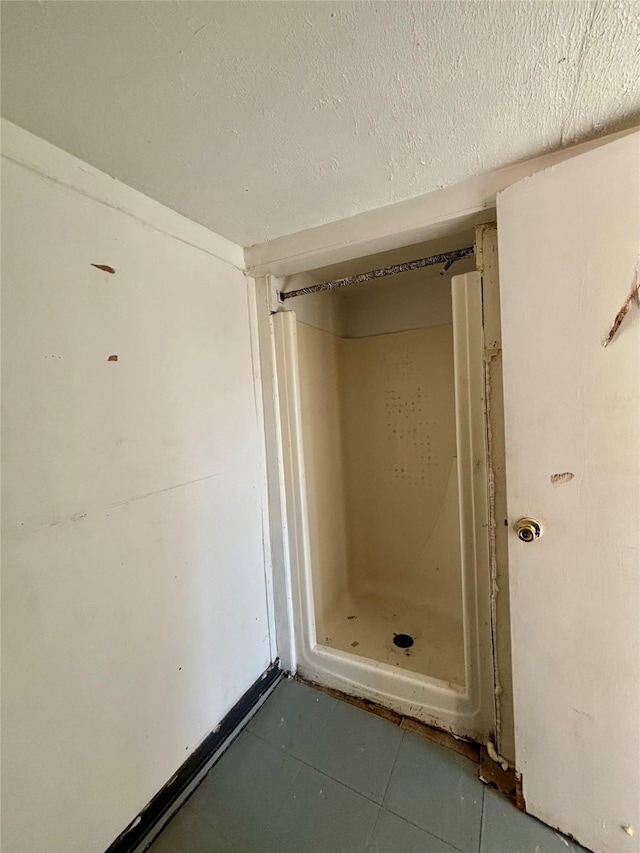 bathroom with tile patterned flooring and a textured ceiling