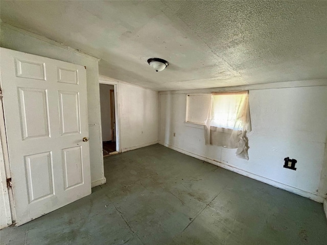 unfurnished room with a textured ceiling