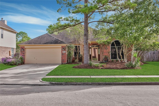 view of front facade featuring an attached garage, driveway, brick siding, and a front yard