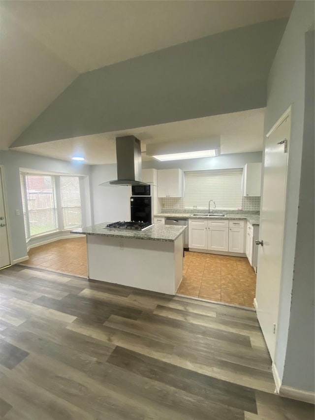 kitchen with a sink, white cabinetry, appliances with stainless steel finishes, decorative backsplash, and island exhaust hood